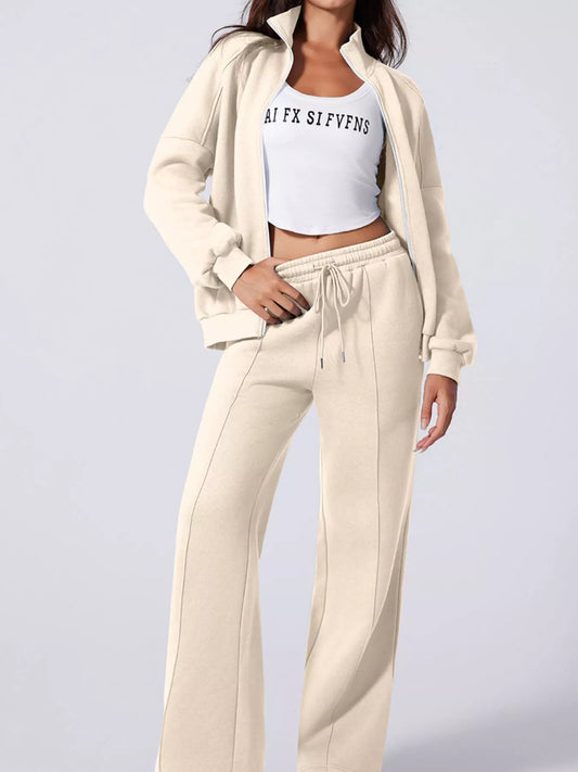 Model showcasing MotionCore Zip-Up Active Set, featuring a relaxed zip-up jacket and comfortable pants for versatile movement.