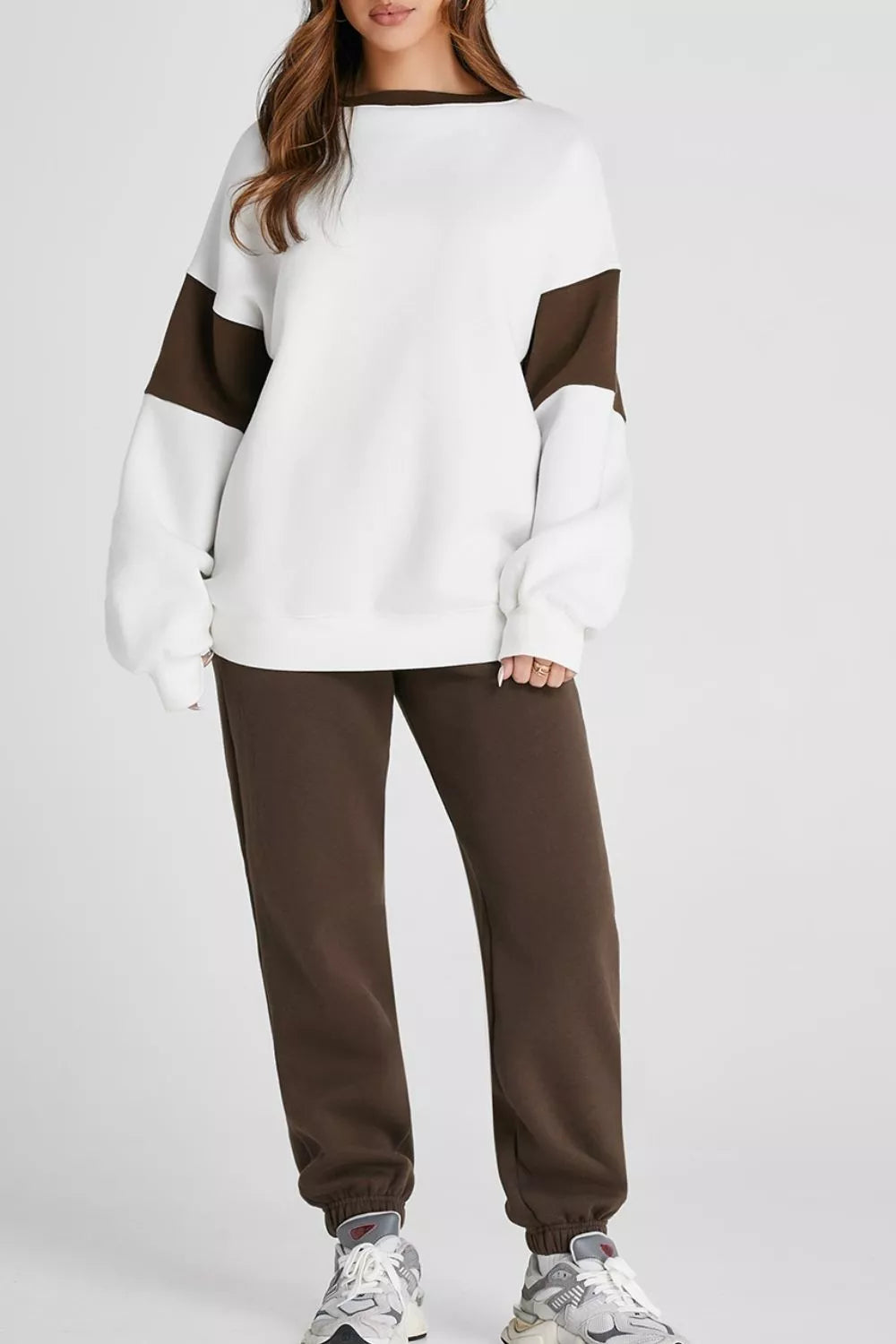 Model wearing MotionFlex Sweatshirt & Jogger Set in white and brown, showcasing relaxed fit and modern athletic style.