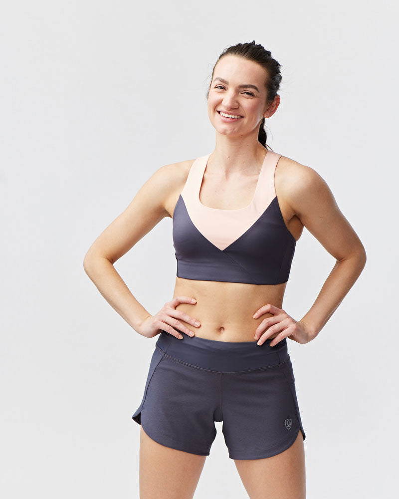 Woman wearing Excel Sculpt Performance Shorts and sports bra, showcasing confidence and comfort in athletic wear.