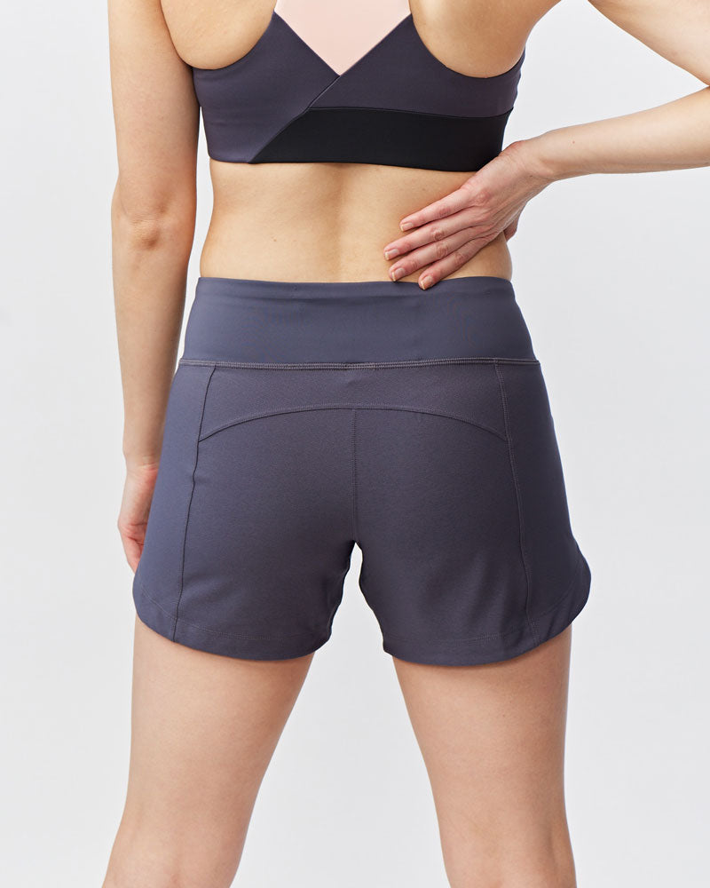 Woman wearing Excel Sculpt Performance Shorts, showcasing the back design and comfort fit for active movement.