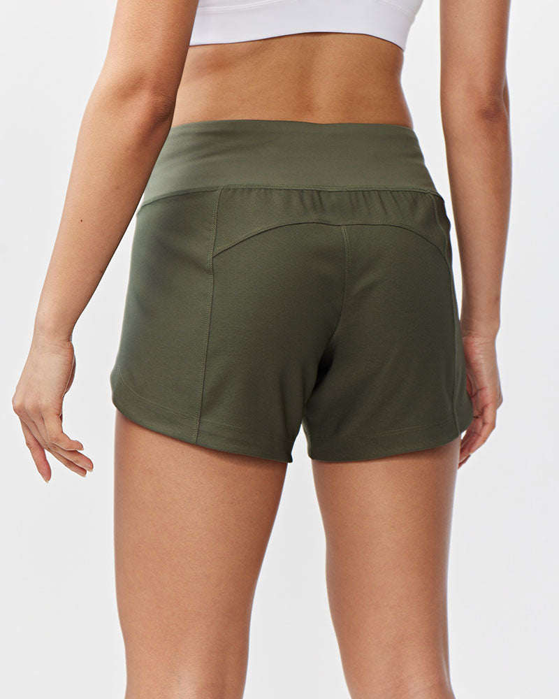Back view of a woman wearing Excel Sculpt Performance Shorts in olive green, showcasing a sleek and comfortable fit.