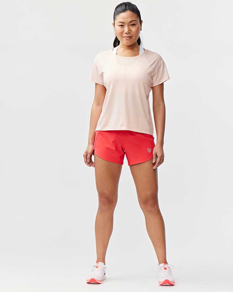 Woman wearing Excel Sculpt Performance Shorts and a pink top, showcasing athletic style and comfort for active movement.
