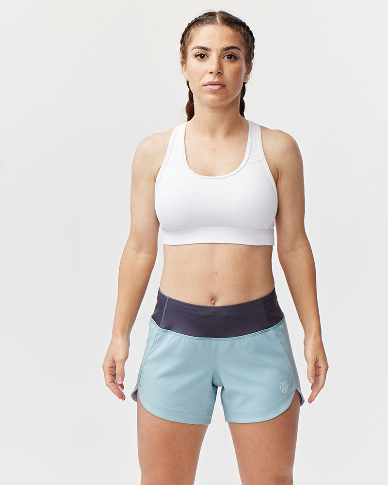 Model wearing Excel Sculpt Performance Shorts and a white sports bra, showcasing active wear for confidence in movement.