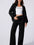 Model wearing MotionCore Zip-Up Active Set, featuring a black zip-up jacket and relaxed pants for active comfort.