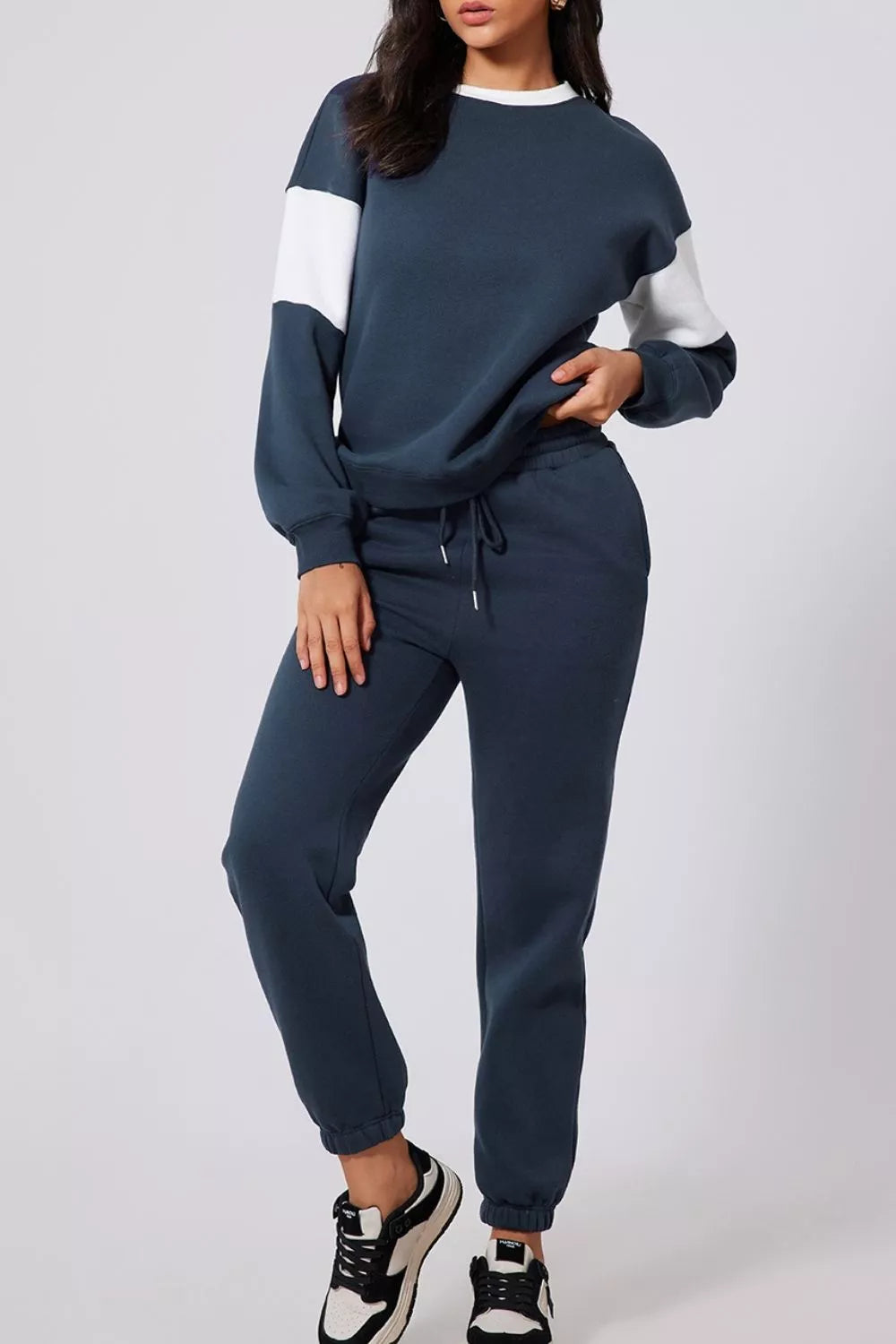 MotionFlex Sweatshirt model wearing a dark blue jogger set with a relaxed fit and stylish design.