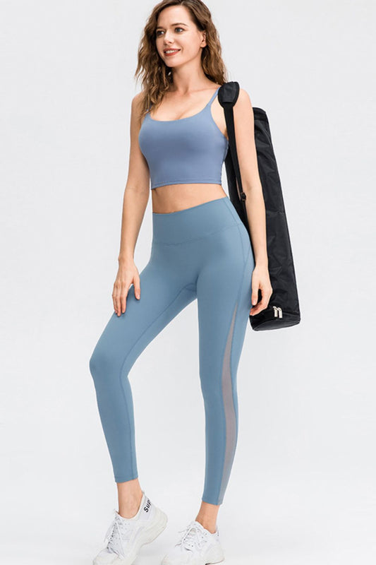 Model wearing CoreLift Wide-Waist Performance Leggings in blue with matching crop top and gym bag.