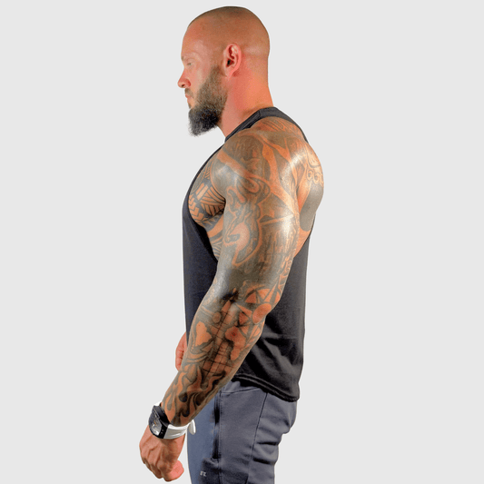 AeroFlex Drop Arm Training Tank showcased by a tattooed man in profile, highlighting athletic style and fit.