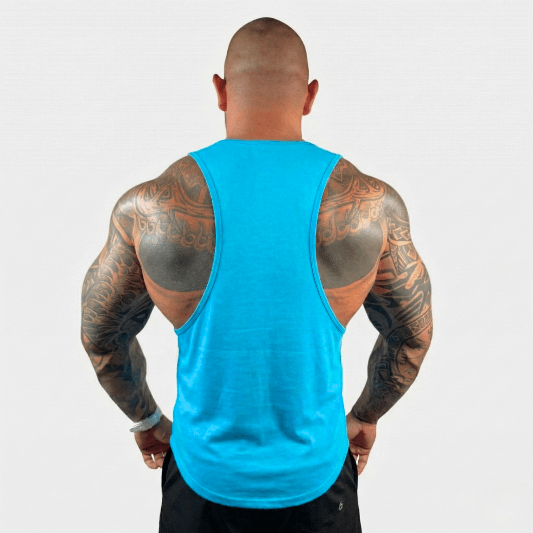 AeroFlex Drop Arm Training Tank in vibrant blue, showcasing a muscular back view with intricate tattoos.
