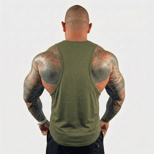 Back view of a muscular man wearing an AeroFlex Drop Arm Training Tank, showcasing tattooed arms.