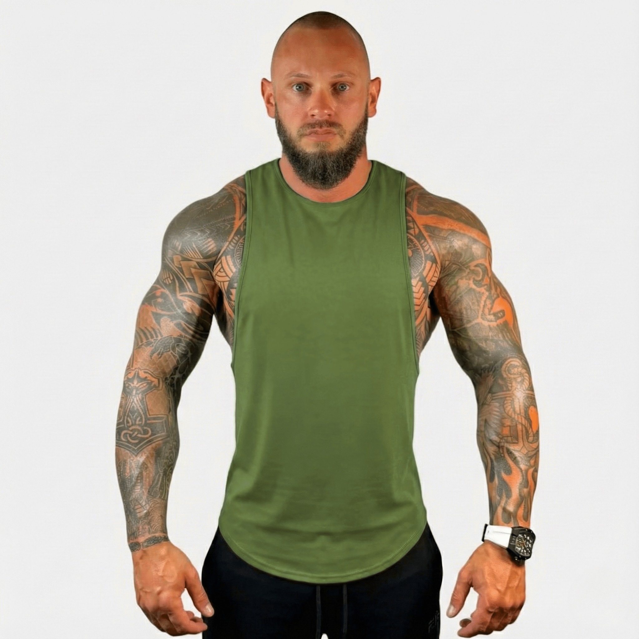 AeroFlex Drop Arm Training Tank on a muscular man with tattoos, showcasing a stylish and comfortable fit for workouts.