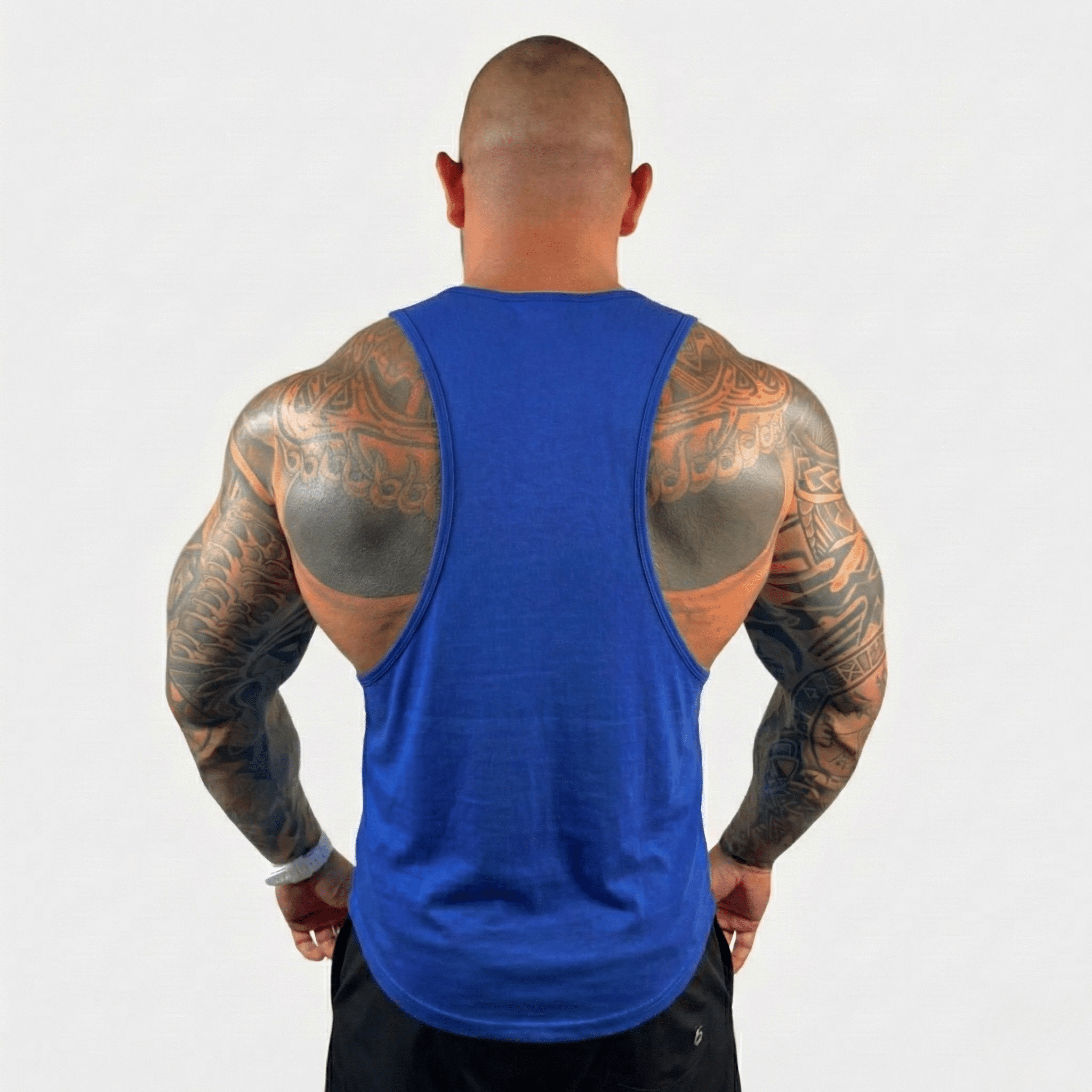 AeroFlex Drop Arm Training Tank in blue, showcasing a muscular back with tattoos, designed for optimal training performance.