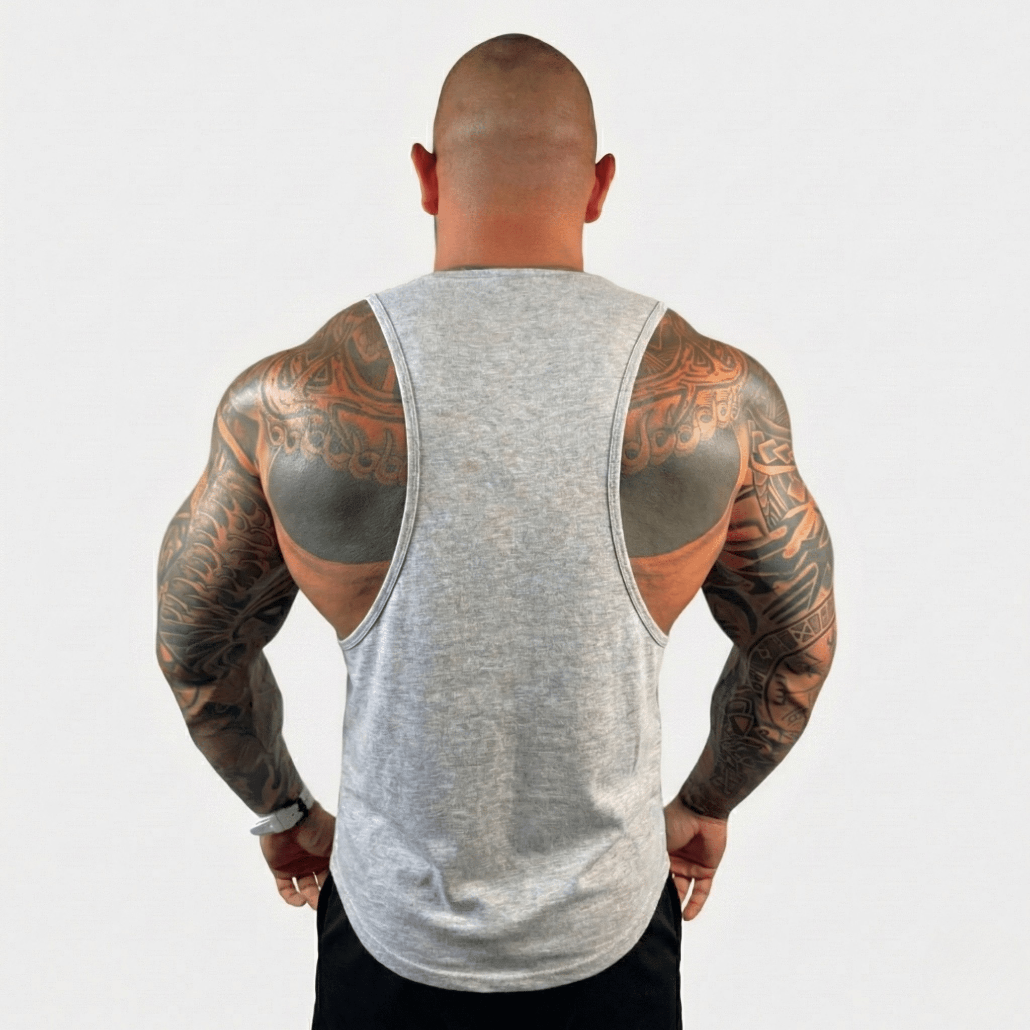 AeroFlex Drop Arm Training Tank worn by a muscular man showcasing tattooed arms from a back view.