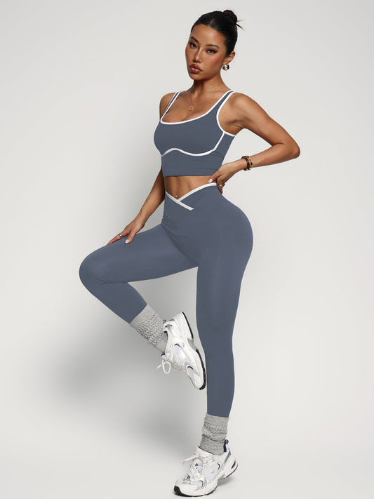 Young woman wearing women's workout outfit set with sports bra tank top and high waist yoga pants in gray color