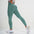 Woman wearing FlexCurve Seamless High-Waist Sculpt Shorts in green, showcasing stylish athletic wear.