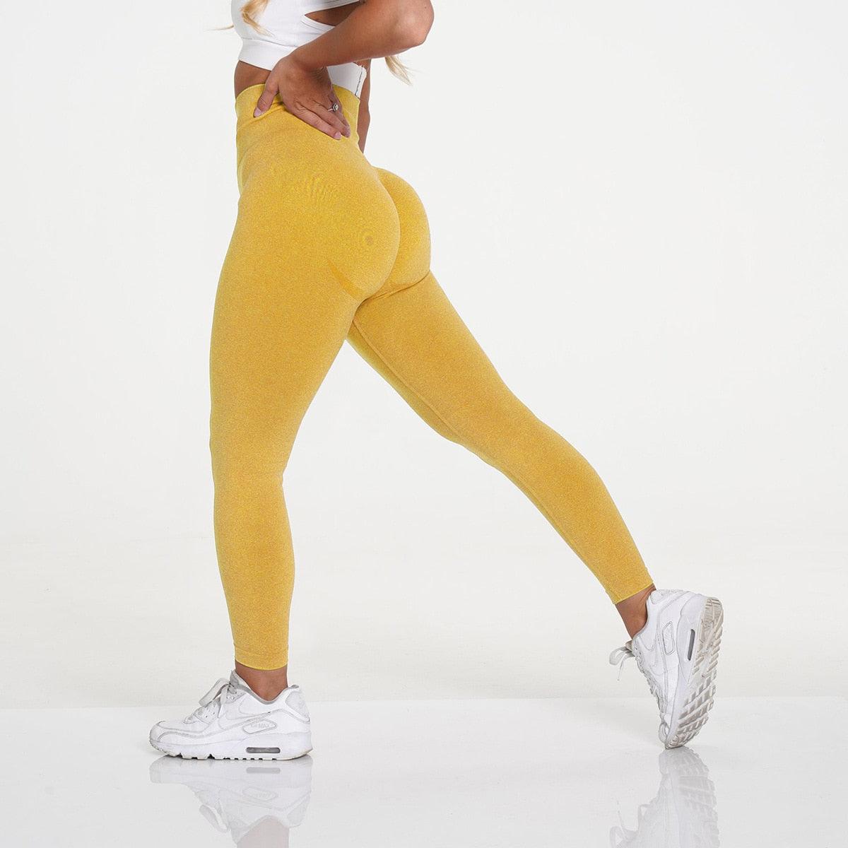 Model showcasing FlexCurve Seamless High-Waist Sculpt Shorts in vibrant yellow, highlighting fit and style.