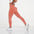 Model showcasing FlexCurve Seamless High-Waist Sculpt Shorts in coral color, emphasizing fit and style.
